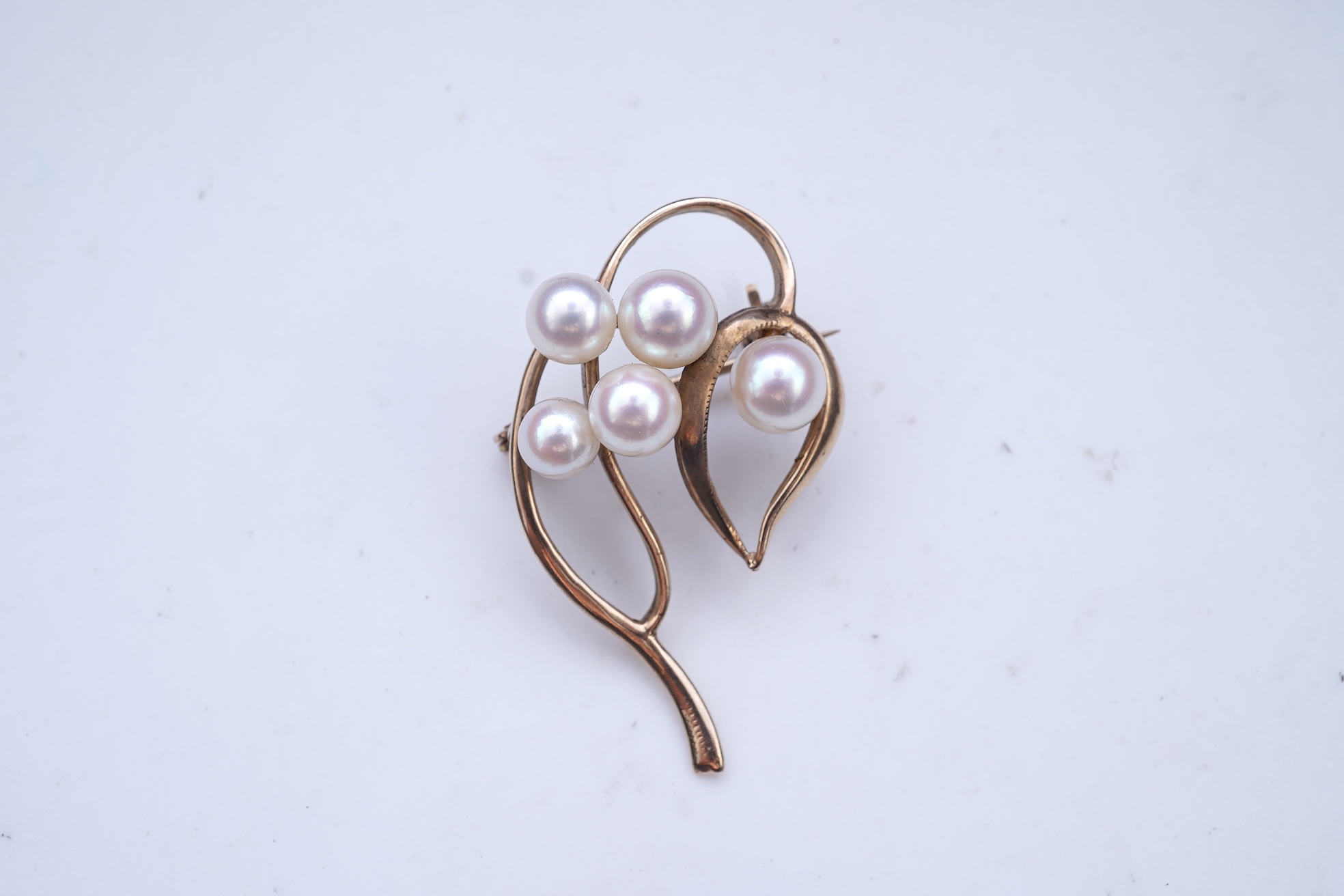A group of cultured pearl jewels, comprising: two pairs of cultured pearl drop earrings, longest 3cm, mounted in gold; and two cultured pearl brooches mounted in 9ct gold, longest 4.1cm, British hallmarks, combined gross
